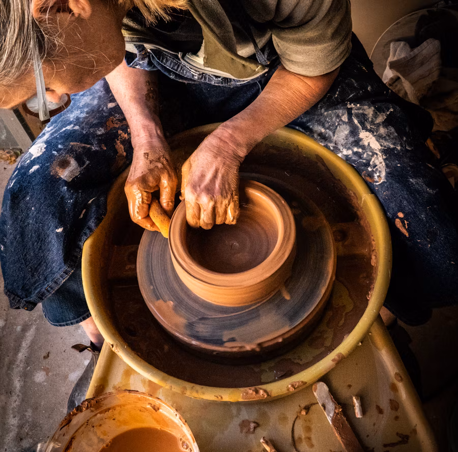 Close up shot of a person building a pottery on a pottery wheel